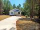 Charming single-story blue home with a covered porch, new driveway, and fresh landscaping at 372 Lippard Farm Rd, Statesville, NC 28625