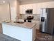 Modern kitchen with white cabinets, granite countertops, and stainless steel appliances at 372 Lippard Farm Rd, Statesville, NC 28625