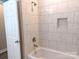 Tub and shower featuring new white marble-style tile and bronze fixtures at 372 Lippard Farm Rd, Statesville, NC 28625