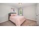Comfortable bedroom with a soft pink bedspread and a large window for natural light at 3816 Ernie Dr, Charlotte, NC 28269
