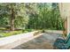 Serene backyard featuring a retaining wall with flowers, mature trees, and lush greenery at 4322 Greenhaven Ln, Gastonia, NC 28056