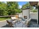 Outdoor deck featuring a cozy fireplace, comfortable seating, and a tranquil backyard view at 4349 Castleton Rd, Charlotte, NC 28211