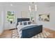 This bedroom is filled with natural light, a blue bedframe, and light hardwood flooring at 4349 Castleton Rd, Charlotte, NC 28211