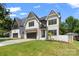 Charming two-story modern farmhouse with stylish brick accents, well-manicured lawn, and long paved driveway at 4349 Castleton Rd, Charlotte, NC 28211
