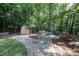 Backyard featuring a fire pit, shed, bench, landscaping, and mature trees at 5051 Carillon Way, Charlotte, NC 28270