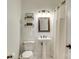 Bathroom featuring pedestal sink, commode, shelving with decor, and shower with curtain at 5051 Carillon Way, Charlotte, NC 28270