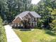 Beautiful two-story brick home with mature trees and a well-manicured lawn at 5051 Carillon Way, Charlotte, NC 28270