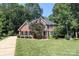 Charming two-story brick home featuring mature trees, manicured lawn, and black shutters at 5051 Carillon Way, Charlotte, NC 28270