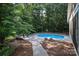 A kidney-shaped pool nestled in a wooded backyard offers a private retreat at 5051 Carillon Way, Charlotte, NC 28270