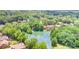 Scenic aerial view of a pond-front property with mature trees and nearby homes in a suburban setting at 5205 Tedorill Ln, Charlotte, NC 28226