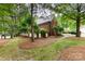 Manicured backyard with mature trees, lush lawn, and a charming brick exterior, creating a serene outdoor space at 5205 Tedorill Ln, Charlotte, NC 28226