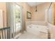 Bright bathroom with a tiled tub and a window for natural light at 5205 Tedorill Ln, Charlotte, NC 28226