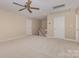 Spacious carpeted bedroom with a ceiling fan, two doors, and a window with natural light at 5205 Tedorill Ln, Charlotte, NC 28226