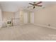 Spacious carpeted bedroom with a ceiling fan, two doors, and a window with natural light at 5205 Tedorill Ln, Charlotte, NC 28226