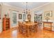 Elegant dining room with hardwood floors, a wooden table set for six, and ample natural light at 5205 Tedorill Ln, Charlotte, NC 28226