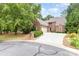 Charming brick home featuring a well-manicured lawn and a spacious driveway leading to an attached garage at 5205 Tedorill Ln, Charlotte, NC 28226