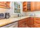 Close-up of a kitchen sink with granite countertops and wood cabinetry with a view from the window at 5205 Tedorill Ln, Charlotte, NC 28226