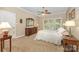Sunlit main bedroom with windows, a ceiling fan, and neutral colored walls at 5205 Tedorill Ln, Charlotte, NC 28226