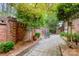 Secluded patio with brick walls, stone pavers, decorative plantings, and wrought iron table and chairs at 5205 Tedorill Ln, Charlotte, NC 28226