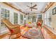 Bright sunroom features hardwood floors, a ceiling fan, multiple windows, and comfortable wicker seating at 5205 Tedorill Ln, Charlotte, NC 28226