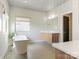 Bright bathroom featuring freestanding tub, modern vanity, stylish fixtures, and decorative ceiling at 628 Cherry St, Charlotte, NC 28204