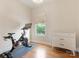 Bedroom featuring an exercise bike, natural light, hardwood floors, and a dresser at 628 Cherry St, Charlotte, NC 28204