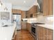 An open kitchen features stainless appliances, wood cabinets and a sleek white countertop at 628 Cherry St, Charlotte, NC 28204