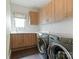 Bright laundry room with a sink, wood cabinets and modern washer and dryer units at 628 Cherry St, Charlotte, NC 28204