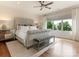 Main bedroom showcasing a tufted bed, hardwood floors, and a large window with natural light at 628 Cherry St, Charlotte, NC 28204