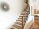 Wooden staircase featuring a modern railing and stair treads, with views into the kitchen at 628 Cherry St, Charlotte, NC 28204