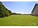 Lush backyard with large grassy area perfect for outdoor activities with green trees on property line at 670 Cricket Ln, Mt Ulla, NC 28125