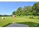 Expansive backyard with green lawn, shed, and mature trees, offering privacy and outdoor enjoyment at 670 Cricket Ln, Mt Ulla, NC 28125