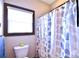 Bright bathroom with a toilet, privacy window, and decorative shower curtain at 670 Cricket Ln, Mt Ulla, NC 28125