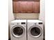 Laundry room features a washer, dryer, and overhead cabinets for a functional and organized space at 670 Cricket Ln, Mt Ulla, NC 28125