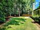 Lush backyard featuring a well-maintained lawn, mature trees, and a charming wooden fence at 7228 Rollingridge Dr, Charlotte, NC 28211
