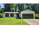 Charming single-story home featuring white siding, green shutters, and a well-manicured lawn with mature trees at 7228 Rollingridge Dr, Charlotte, NC 28211
