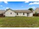 Wide shot of large backyard with an air conditioning unit and an awning over the sliding door at 7616 Shiny Meadow Ln, Charlotte, NC 28215
