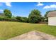 Large, grassy backyard bordered by mature trees and a wooden fence; perfect for outdoor activities at 7616 Shiny Meadow Ln, Charlotte, NC 28215