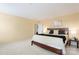 Bedroom with neutral walls, plush carpeting, and comfortable bed with lamps and side table at 7616 Shiny Meadow Ln, Charlotte, NC 28215
