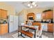Bright eat-in kitchen featuring wood cabinets, white appliances, and modern table with bench seating at 7616 Shiny Meadow Ln, Charlotte, NC 28215