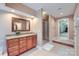 Bathroom featuring wood cabinets with granite counters, framed mirror, glass enclosed shower, and neutral color scheme at 844 Clonmel Dr, Matthews, NC 28104