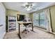 Cozy bedroom featuring an adjustable desk, ceiling fan, neutral walls, natural light and built in shelving at 844 Clonmel Dr, Matthews, NC 28104