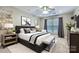 A serene bedroom with a ceiling fan, neutral decor, a patterned bedspread, and natural light at 844 Clonmel Dr, Matthews, NC 28104