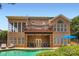 An expansive brick home with a multi-level deck overlooks a pristine pool and outdoor lounge area at 844 Clonmel Dr, Matthews, NC 28104