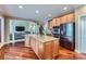 Open kitchen with granite island, stainless steel appliances, hardwood floors, and adjoins living area at 844 Clonmel Dr, Matthews, NC 28104