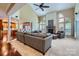 Open-concept living area with a stone fireplace, tall windows, and a large sectional sofa at 844 Clonmel Dr, Matthews, NC 28104