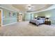 Large main bedroom with a tray ceiling, carpet flooring, and access to ensuite bathroom at 844 Clonmel Dr, Matthews, NC 28104