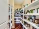 Walk-in pantry with hardwood floors and well-organized white shelving filled with food items and household supplies at 844 Clonmel Dr, Matthews, NC 28104