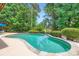 A serene in-ground pool surrounded by lush greenery offers a private oasis for relaxation at 844 Clonmel Dr, Matthews, NC 28104