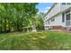 Large, green backyard surrounded by mature trees with manicured hedges along the perimeter at 9833 White Cascade Dr, Charlotte, NC 28269
